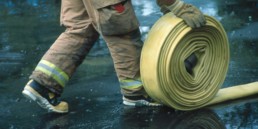 Firefighter rolling up hose