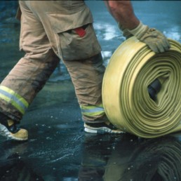 Firefighter rolling up hose