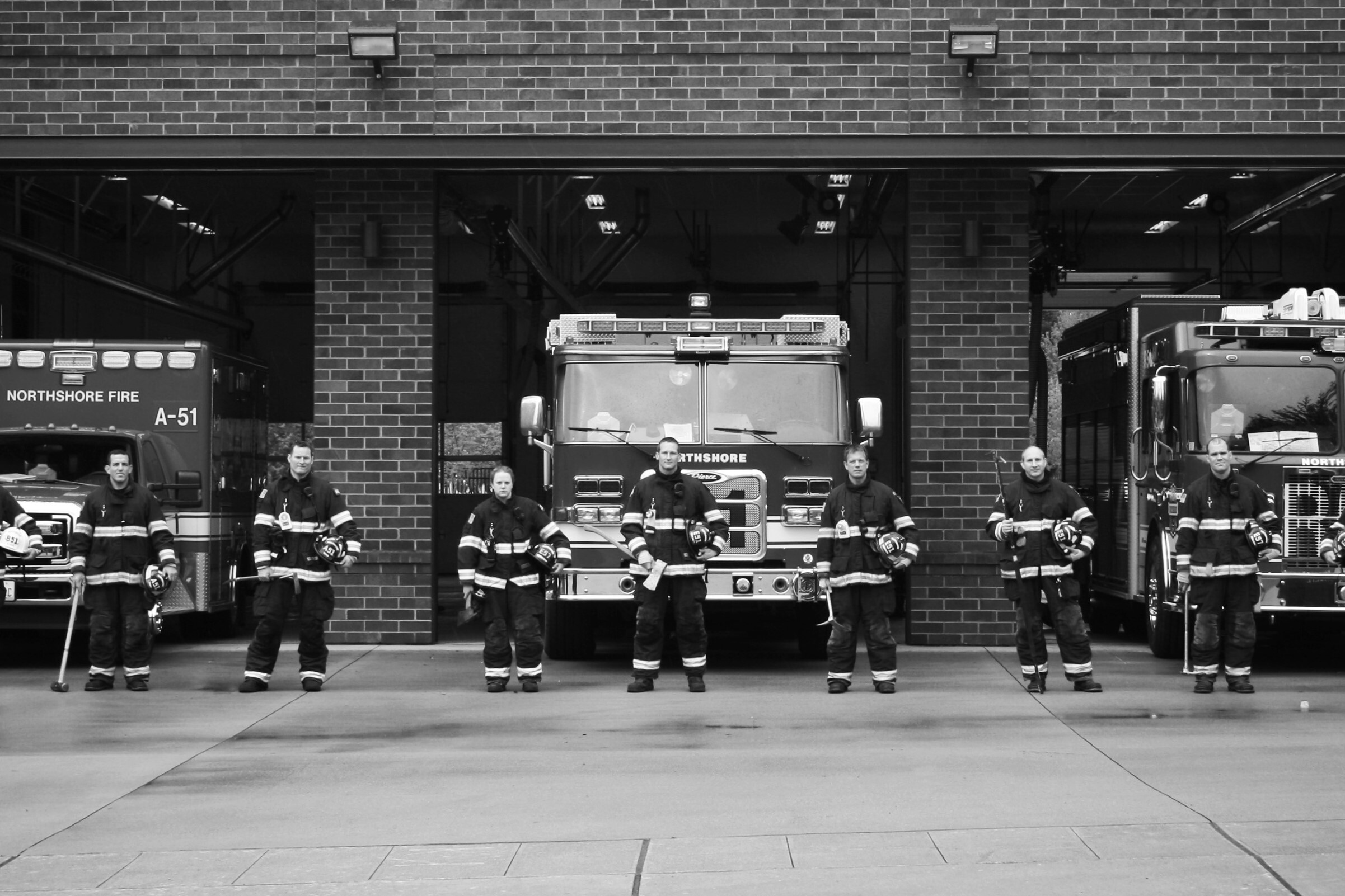 Fire fighters posing in front of engines