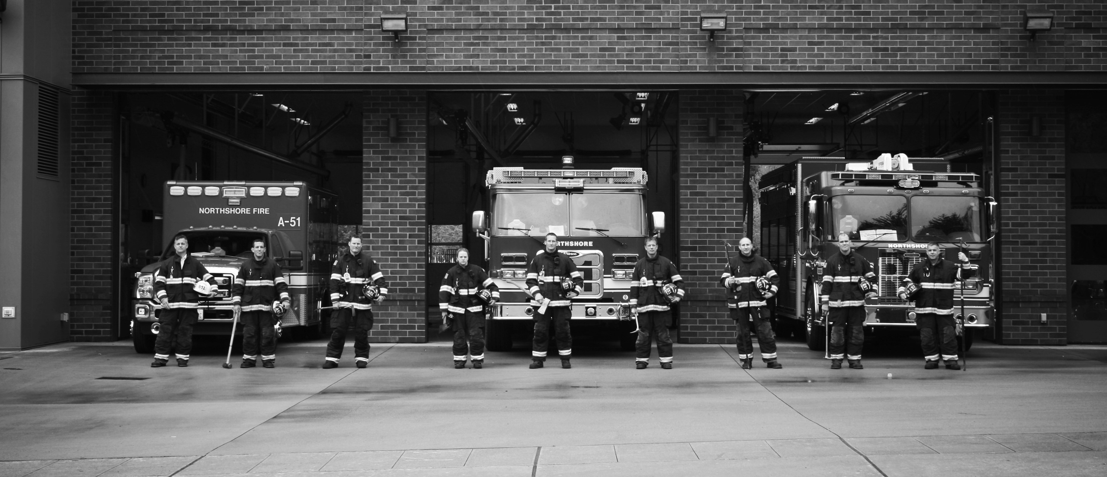 Fire fighters posing in front of engines