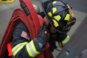 Northshore Firefighter carrying hose on shoulder