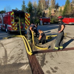 Northshore Fire Department team rolling up hose
