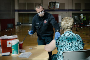 Medic giving COVID vaccine shot