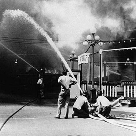 Historical photo of Firefighters spraying fire hose